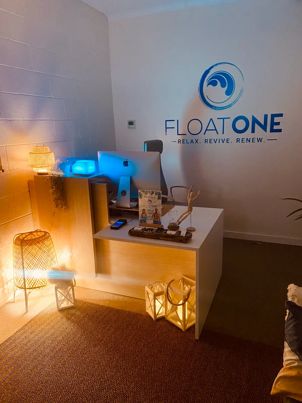 The warmly lit reception desk at Float One Glasgow